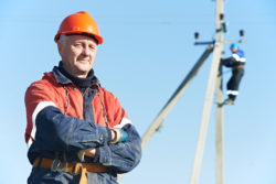 Portrait of electrician lineman repairman worker on electric post power pole line work