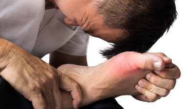 Uloric cardiovascular side effects gout man holding foot in pain
