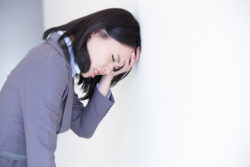 Unhappy thinking business woman with white wall background, great for your design or text, asian