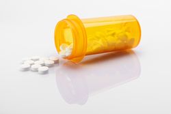 Various pills in pills bottle on a white background.