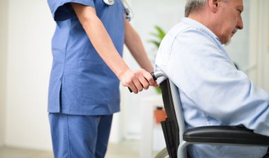 Nurse pushing a nursing home patient on a wheelchair