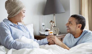 A sick woman in bed with her partner