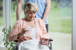 Old woman on a wheelchair taking pills