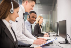 Manager explaining something to his employee in a call centre.