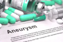 Aneurysm - Printed Diagnosis with Blurred Text. On Background of Medicaments Composition - Mint Green Pills, Injections and Syringe.