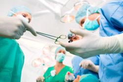 Hospital - surgery team in the operating room or Op of clinic operating on patient in an emergency situation