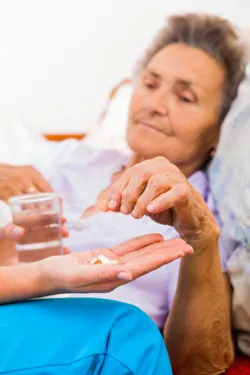 Elderly lady with Alzheimer's disease taking pills.