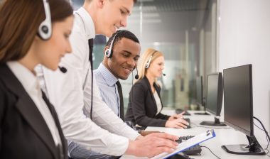 Manager explaining something to his employee in a call centre.