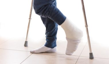 Young man with a broken ankle and a leg cast