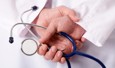 Hands of practitioner with stethoscope, hip recall