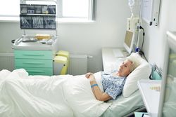 Senior female being sick in hospital bed