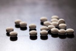 Backlit white pills - Opioid and prescription medication addiction epidemic or crisis - concept
