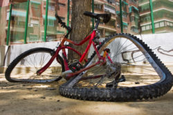 Close up photo of a bicycle totally broken in the floor.