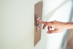 female finger pushing elevator button