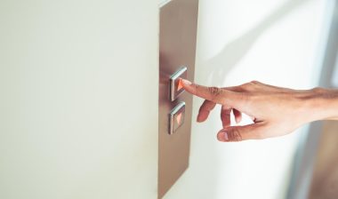 female finger pushing elevator button