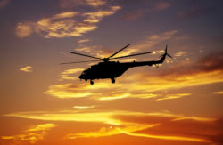 Picture of helicopter at sunset. Silhouette of helicopter on sunset sky.