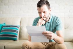 New York FDCPA man reading debt collection letter