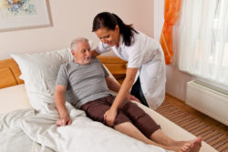 Home Helpers senior care nurse helping patient into bed