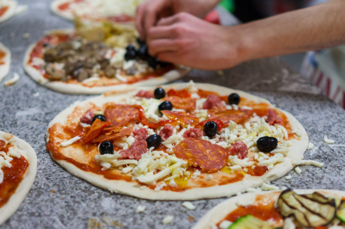 prepare raw pizza in pizzeria