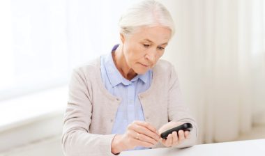 Invokana Invokamet ketoacidosis amputation medicine, age, diabetes, health care and people concept - senior woman with glucometer checking blood sugar level at home