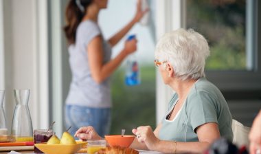 in home elder care worker with woman having breakfast
