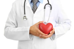 Doctor holding toy heart, illustrating risk of peripheral artery disease