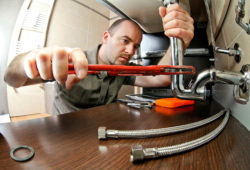 Plumber installing drain and water connector hose