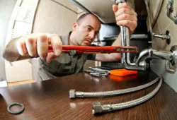 Plumber installing drain and water connector hose