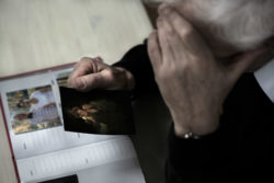 widower looking at pictures of wife he lost to lung cancer from asbestos