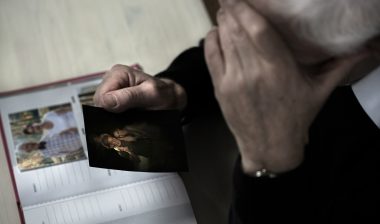 widower looking at pictures of wife he lost to lung cancer from asbestos