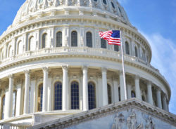 Capital building with american flag flying.