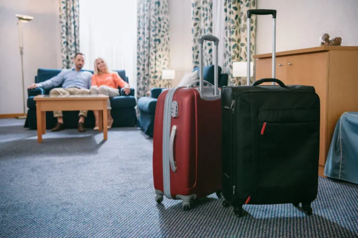 couple sitting in hotel room that they booked on Expedia