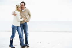 A couple is walking on the beach.
