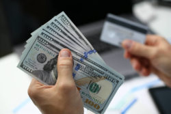 hand holds cash and bank card