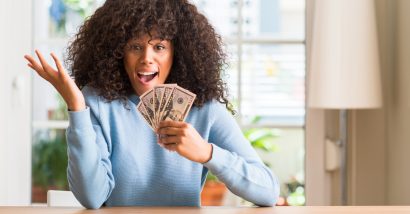 woman holding cash money she got from a settlement checks