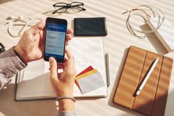 hands holding smartphone checking online banking account