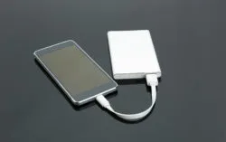 A smartphone is connected to a portable charger.