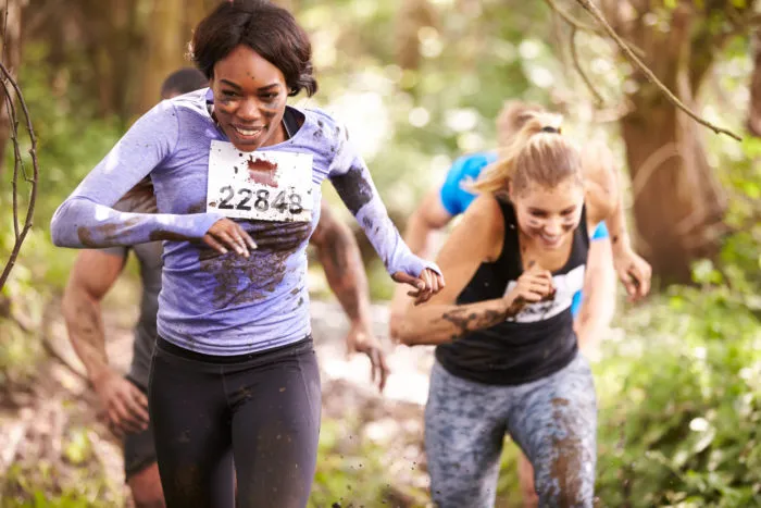 women covered in mud enjoying the Tough Mudder endurance race