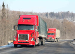 two red semi trucks on the highway