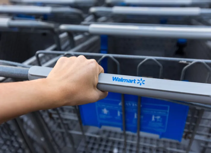 walmart shopper holding onto cart