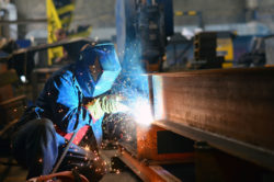 A welder is welding a steel beam.