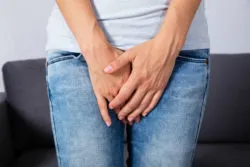 A woman's hands in front of her vaginal area.