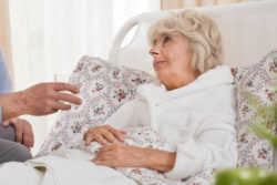 An ill woman in bed.