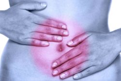 Woman in pain with hands on abdoment