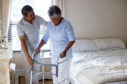 Man helping woman with walker