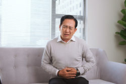 Man on a sofa with stomach pain