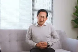 Man on a sofa with stomach pain