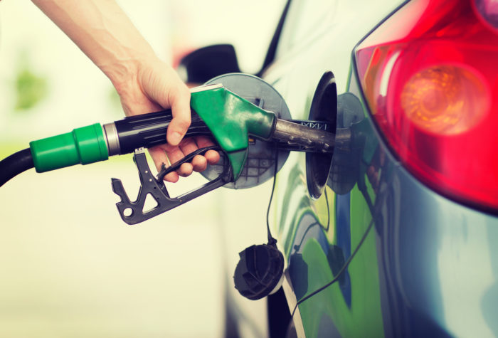 man pumping gasoline fuel into vehicle that contains additech fuel cleaner