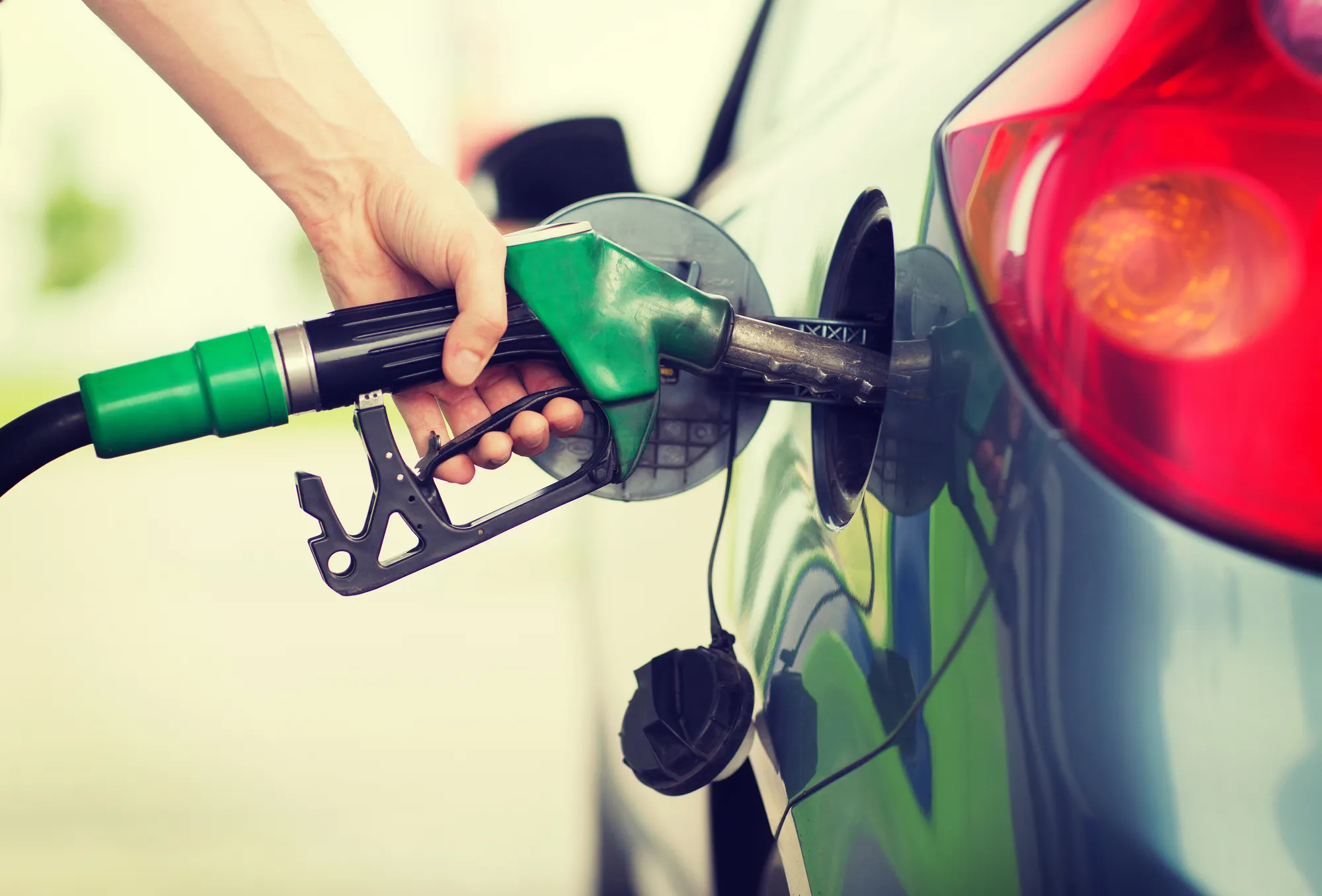 man pumping gasoline fuel into vehicle that contains additech fuel cleaner - Valero gas prices