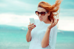 Angry redhead woman holding cell phone